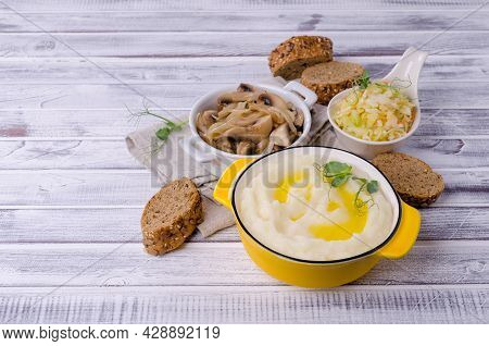 Mashed Potatoes With Butter, Fried Mushrooms With Onions And Salad Of Fresh Vegetables On Light Wood