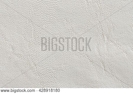 Light Embossed Texture Of Eco-leather Dermantin Of White Color. Background Light Artificial Leather 