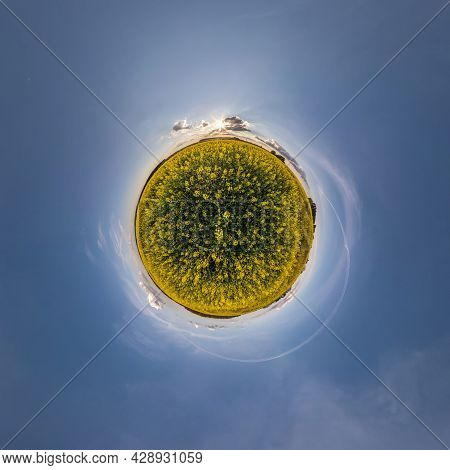 Yellow Tiny Planet In Rapeseed Field In Blue Sky With Beautiful Clouds. Transformation Of Spherical 