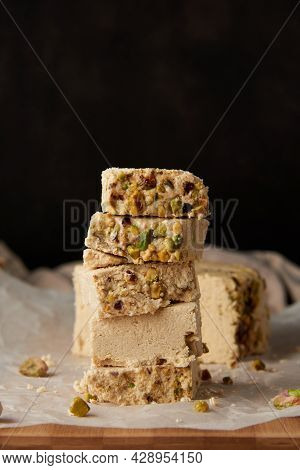Organic Halva With Pistachios On A Wooden Surface. Traditional Middle Eastern Sweets. Jewish, turkis