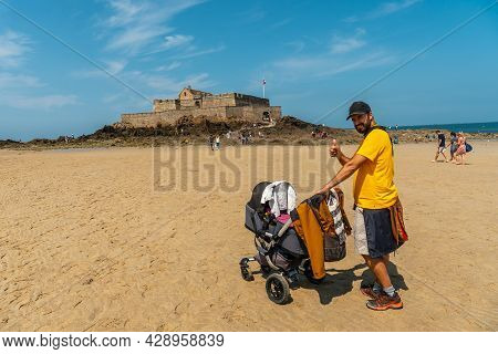 A Young Father Enjoying The Summer On The Grande Plage Du Sillon De Saint-malo In French Brittany, F