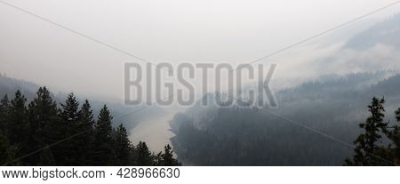 Trees On The Side Of A Mountain In A Valley Covered By Smoke From Forest Wildfire. Nature Disaster. 