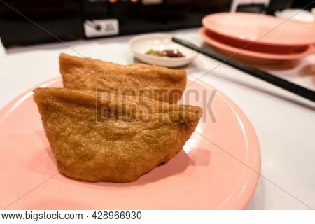 inarizushi on a dish at a fast sushi restaurant