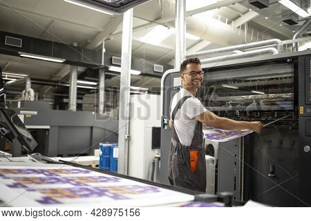 Worker Taking Imprint From Modern Printing Machine To Do Color Matching And Quality Control.