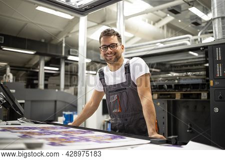Portrait Of Worker At Control Room Checking Print Quality At Printing House.
