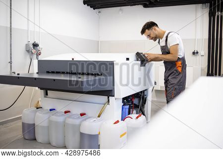 Print Worker Operating Computer To Plate Machine In Print Shop.