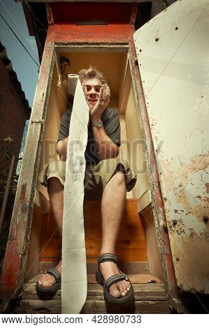 Man Using Wooden Toilet Latrine On Summer Cottage