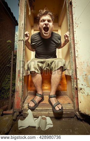 Man Using Wooden Toilet Latrine On Summer Cottage