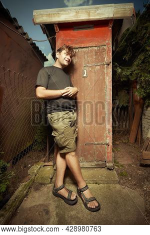 Man Leaving Wooden Toilet Latrine On Summer Cottage