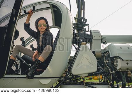 Brunette Tweenager In Mirrored Sunglasses Sitting In Open Helicopter Cockpit