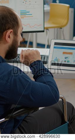 Disabled Handicapped Immobilized Paralyzed Manager Man Using Computer And Tablet In Same Time Workin