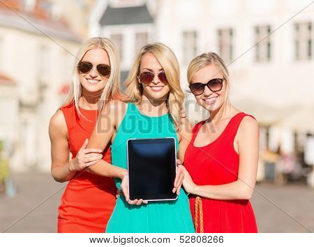 holidays and tourism concept - beautiful blonde girls toursits showing tablet pc with blank screen in the city