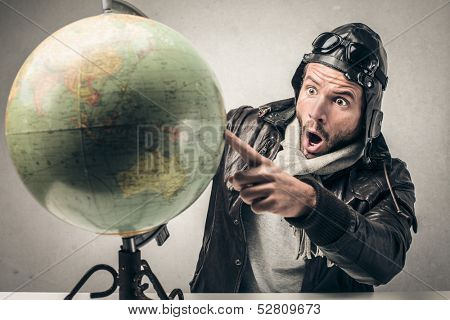 amazed aviator indicates a country on the globe