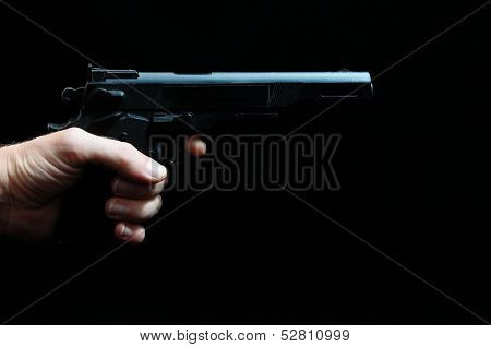 Waffe und eine Hand auf schwarzem Hintergrund