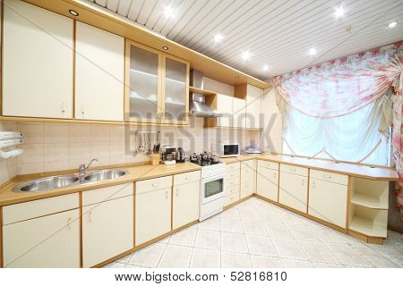 Interior of modern kitchen with beige furniture and a stove