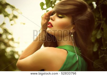 Portrait close up of young beautiful woman, on green background summer nature.