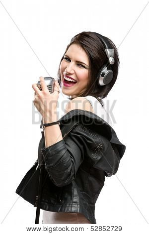 Half-length portrait of rock musician with earphones wearing leather jacket and keeping static mic, isolated on white. Concept of rock music and rave