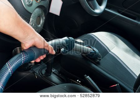 closed up a man is Cleanning A Car By Using Vacuum Cleanner