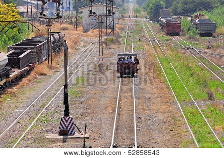 Railroadmen arrive by handmade vehicle.