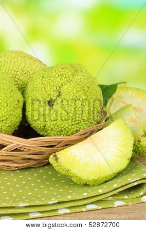 Osage Orange fruits (Maclura pomifera) in basket, on nature background