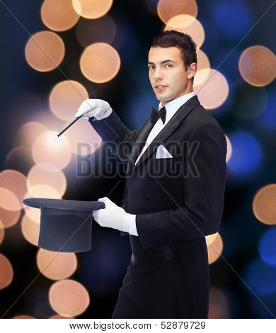 performance, circus, show concept - magician in top hat with magic wand showing trick