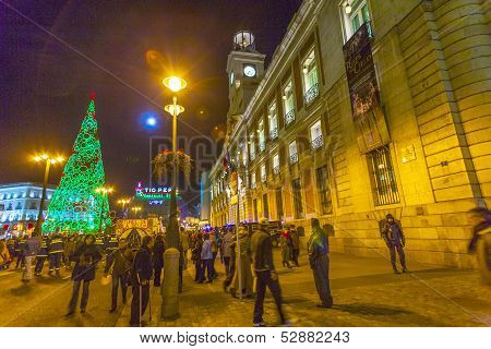 People Have Fun In Christmas Time Passing A  Illuminated Christmas Tree