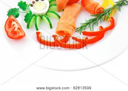 smoked salmon slices with vegetabls over white plate