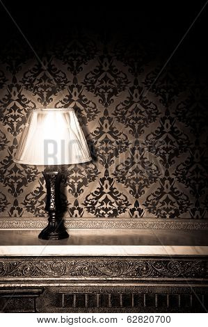 Vintage Lamp On Old Fireplace In Room With Red Rocco Pattern