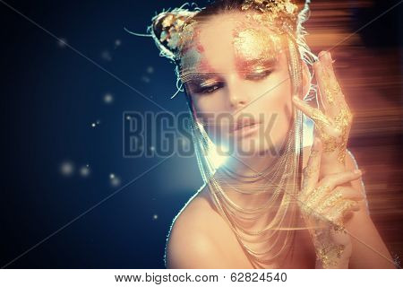 Art project: beautiful woman with golden make-up. Jewelry, make-up. Fashion. Light effects.