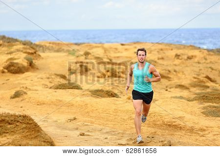 Athlete man running. Male runner cross country running and jogging training on trail outdoors on Big Island, Hawaii, USA
