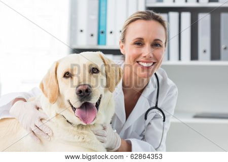 Portrait of confident female veterinarian with dog in clinic