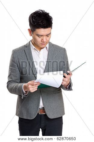 Asia businessman concentrate reading on clipboard