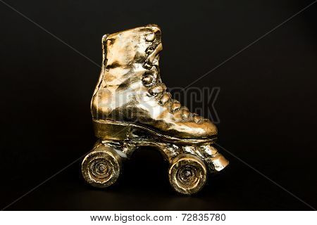 Golden Roller Skate Against Black Background