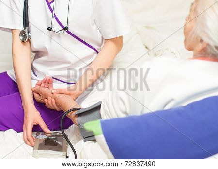 Taking Blood Prssure For An Old Patient Lyin In Bed