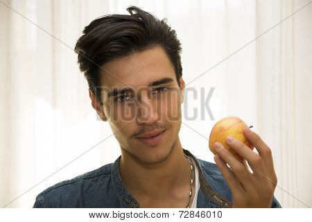 Young Man Holding A Large Delicious Ripe Apple