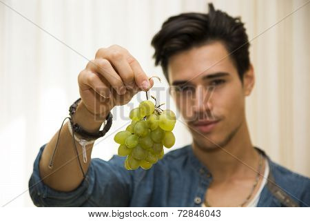 Young Man Holding A Large Delicious Ripe Bunch Of Grapes