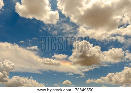 High clouds in a bright blue sky features a sundog rainbow