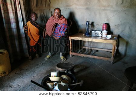Internal View Of Maasai Hut, Black Woman And Children  Indoors.