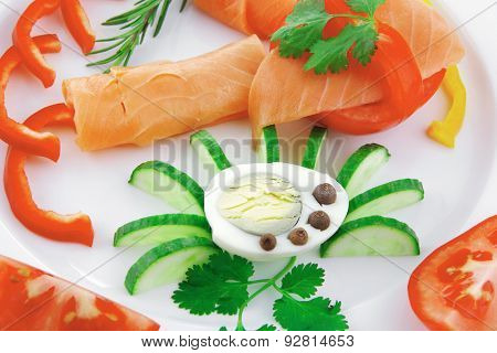 smoked salmon slices with vegetabls over white plate