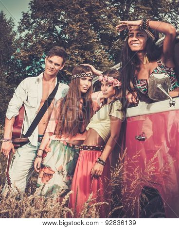 Multi-ethnic hippie friends with guitar on a road trip
