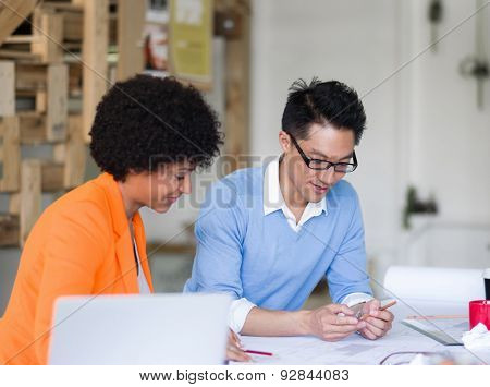 Two desingers working on a project together in office