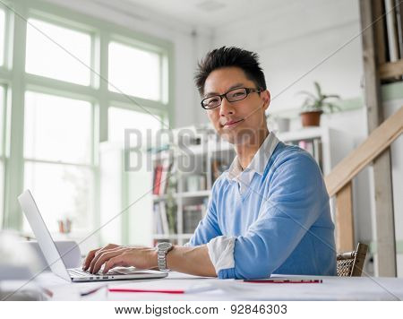 Young chineese engineer working in office