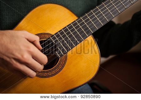 Detail of a man playing a guitar