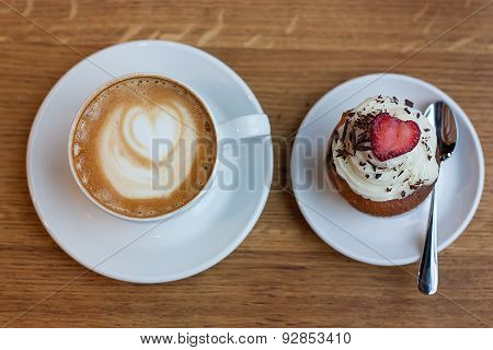 Cup Of Cappuccino And Cupcake On Wooden Table