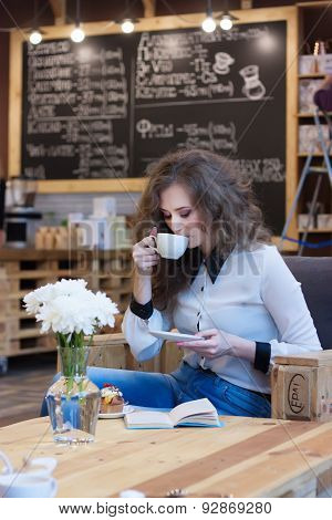 Beautiful Girl Drinking Coffee In A Coffee Shop