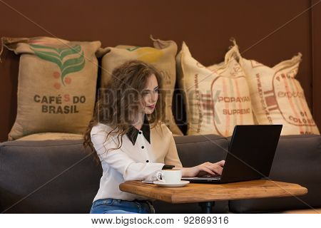 Beautiful Girl Working On A Laptop In A Cafe