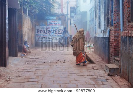 Indian Woman Sweeps Street Cold Foggy Winter Morning In Varanasi