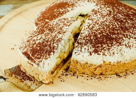 Banoffee pie on wooden plate in soft light