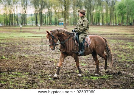 Unidentified woman re-enactor dressed as Soviet soldier ride on