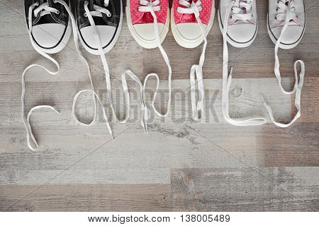 Pairs of shoes on a wooden parquet. Family concept